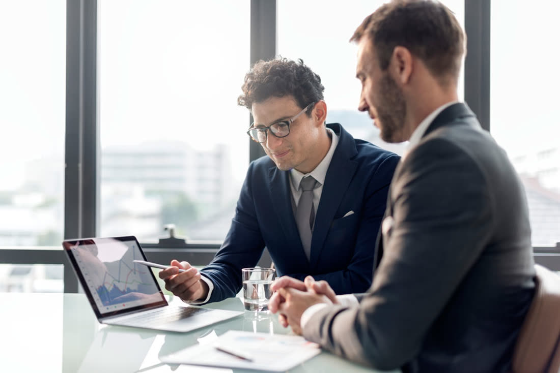 Advisor reviewing a chart on a laptop with a client